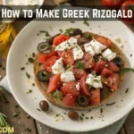 Plate of traditional Cretan Dakos salad with barley rusks, grated tomatoes, mizithra cheese, olives, and olive oil