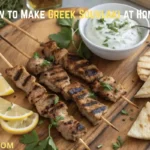 Alt Text: Platter of grilled Greek Souvlaki skewers with pita bread, tzatziki, and lemon wedges