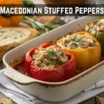 Dish of Macedonian-style Greek stuffed bell peppers filled with rice and herbs in tomato sauce